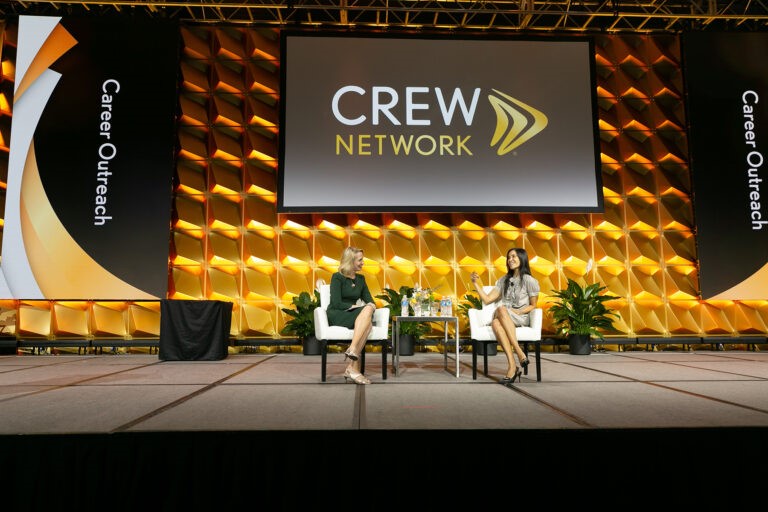 CREW Network two females in discussion on stage
